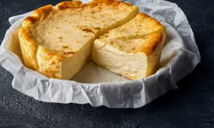 Un délicieux fiadone, recette corse, est servi sur du papier sulfurisé. Sa croûte dorée et sa texture crémeuse invitent à la dégustation.
