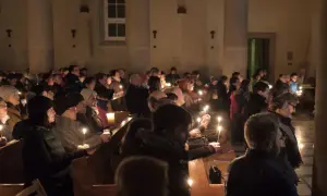 Ludzie z zapalonymi świecami w kościele podczas Rorat. Trwają one przez 24 dni Adwentu.