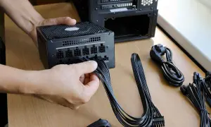 Persona conecta cables a una fuente de alimentación de PC. Es el momento de comprobar fuente de alimentación pc.