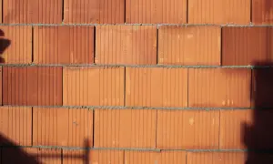 Ściana z pustaków ceramicznych. Widoczne są pionowe i poziome fugi. Pustak ceramiczny wymiary są standardowe, idealne do budowy.