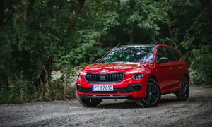 Czerwona Skoda Kamiq na leśnej drodze. Wiele osób szuka skoda kamiq opinie, by poznać ten model.