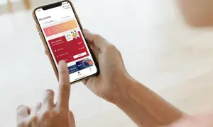 Osoba korzysta z aplikacji Airalo na telefonie, pokazując, jak działa usługa eSIM. Widoczne są aktywne pakiety danych i opcja doładowania.