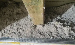 Izolacja z celulozy, która to ekologiczny materiał, wypełnia przestrzeń między drewnianymi belkami stropowymi.
