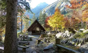 Holzhütte mit Bänken und bunten Bäumen im Herbst. Perfekt für eine Seealpsee Wanderung.