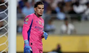 Bramkarz Manchester City w różowym stroju, gotowy do obrony bramki.