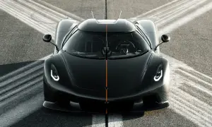 Czarny Koenigsegg Jesko z pomarańczowym pasem na masce, gotowy do startu na torze.