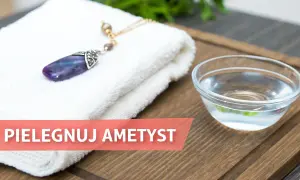Ametyst, kamień urodzeniowy Ryb, leży na białym ręczniku obok miseczki z wodą.
