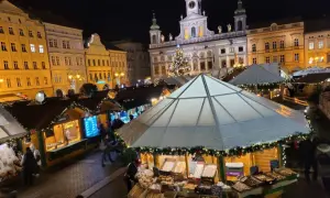 Festlicher budweis weihnachtsmarkt mit beleuchteten Buden, einem Weihnachtsbaum und historischen Gebäuden im Hintergrund.