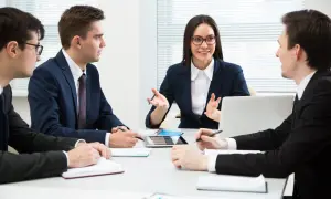 Team discute strategie di gestione del personale, analizzando dati su tablet e quaderni per ottimizzare le risorse umane.