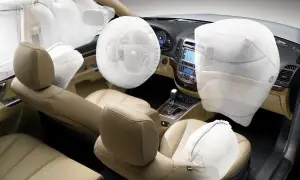 Wnętrze samochodu z widocznymi, nadmuchanymi poduszkami airbag, chroniącymi pasażerów.