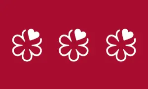 Tres flores blancas con un corazón en cada una, sobre fondo rojo. Símbolo de excelencia culinaria, como en restaurantes con 4 estrellas Michelin.