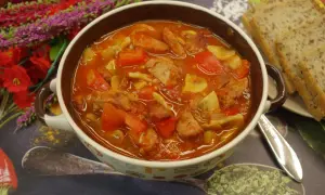 Pyszne leczo Ania gotuje, pełne mięsa, papryki i pomidorów, podane z chlebem.
