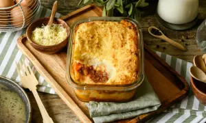 Un delicioso pastel de carne gratinado, listo para servir. Acompañado de queso rallado, huevos y especias.