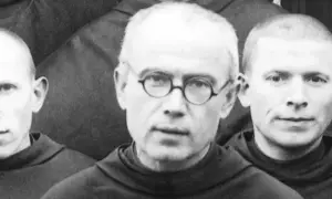Trzej zakonnicy w habitach. W środku Maksymilian Kolbe w okularach. Ciekawostki o jego życiu i heroizmie.
