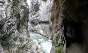 Sendero tallado en roca junto a un río caudaloso, parte de la ruta cain.