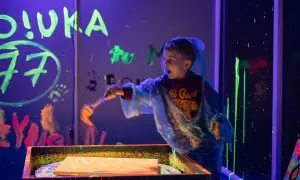 Chłopiec maluje farbami fluorescencyjnymi w ciemni. Świetne atrakcje dla dzieci w Szczecinie!