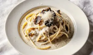 Pyszny makaron z truflami w kremowym sosie, posypany parmezanem i kawałkami czarnej trufli.