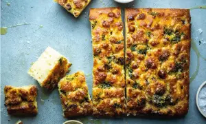 En gyllene focaccia långpanna, skuren i bitar, med örter och flingsalt. Perfekt för en mysig fika.