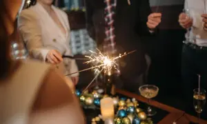 Ludzie trzymają zimne ognie, świętując Nowy Rok. Pamiętaj, czego nie robic w nowy rok, by zabawa była bezpieczna.