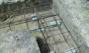 Zbrojenie wieńca w narożu fundamentu, gotowe do zalania betonem. Stalowe pręty tworzą solidną konstrukcję.