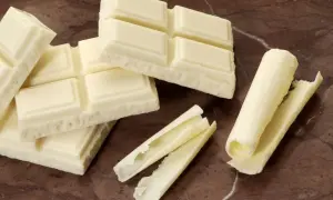 Barras de chocolate blanco, algunas enteras y otras desmenuzadas, demuestran que el chocolate blanco es chocolate.