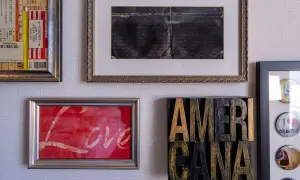 Ściana z obrazami: bilety na koncert, ręcznie pisany list, obraz z napisem "Love" i dekoracja "AMERICANA".