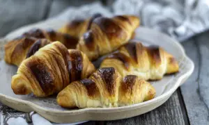 Une assiette de croissants italiens dorés et feuilletés, prêts à être dégustés.