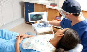 Dentysta omawia z pacjentką zdjęcie RTG, szukając rozwiązań co zamiast leczenia kanałowego.