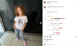 Dziewczynka z kręconymi włosami w koszulce z wizerunkiem dziewczyn. Ile Norbi ma dzieci? Na zdjęciu widać tylko jedną córkę.