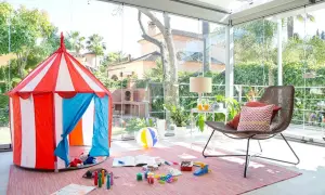 Tienda de circo y juguetes para disfrutar de juegos de patio en un espacio acristalado con vistas al jardín.