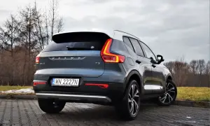 Tylny widok na ciemnoszary Volvo XC40 T3 z białym dachem, zaparkowany na brukowanej nawierzchni.