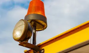 Un gyrophare orange et un phare sont fixés sur une structure jaune. Le schéma électrique de branchement gyrophare est visible.