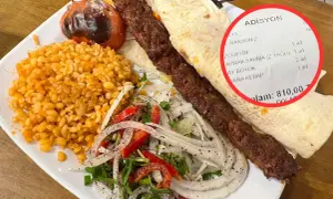 Talerz z daniem kebab, ryżem, sałatką i rachunkiem z ceną 810,00.