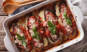Un plat de parmigiana sicilienne tout juste sorti du four, avec des aubergines, de la sauce tomate, du fromage fondant et du basilic frais.