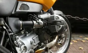 Zbliżenie na silnik motocykla z żółtym bakiem i elementami układu paliwowego.