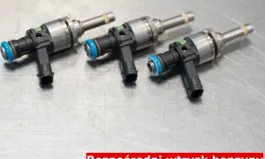 Trzy wtryskiwacze do silnika benzynowego z bezpośrednim wtryskiem (GDI) leżą na metalowej powierzchni.