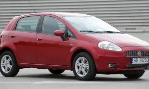 Czerwony Fiat Grande Punto, przód. Wymiana żarówki w reflektorze przednim jest prosta.