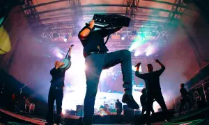 Energetyczny koncert Dropkick Murphys. Muzyk gra na akordeonie, inny na banjo, tłum szaleje.