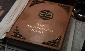 Brązowa księga z napisem "The Neverending Story" i wężami oplatającymi się na okładce.