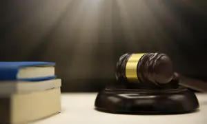 Młotek sędziowski i książki. Czy synowa dziedziczy po teściowej? Prawo i sprawiedliwość.