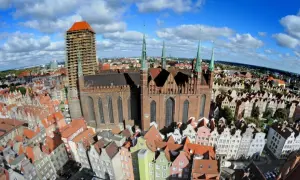 Widok z lotu ptaka na Gdańsk, z dominującym Kościołem Mariackim i kolorowymi kamieniczkami.