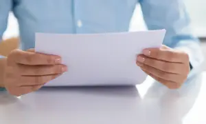 Dłonie trzymają dokument, który może dotyczyć zmiany nazwiska.
