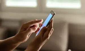 Dłonie trzymają smartfon, na którym można sprawdzić ile lat ma telefon.