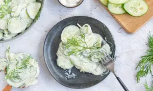 Cremiger Gurkensalat mit Schmand und frischem Dill, garniert mit Dillzweigen. Ein erfrischender Genuss!