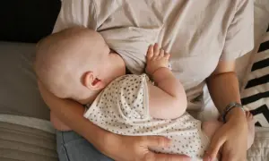 En bebis ammar. En mamma håller sitt barn nära. Dagen efter piller amning kan kännas annorlunda, men lugnet i stunden är detsamma.