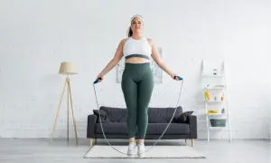 Frau springt Seil in einem Wohnzimmer. Sie fragt sich, wieviel bewegung pro woche ideal ist.