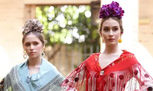 Dos jóvenes con maquillaje flamenca, flores en el pelo y mantones de seda.