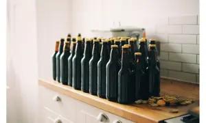 Rząd ciemnych butelek piwa, gotowych do degustacji. Zestaw brewkit Coopers czeka na otwarcie.
