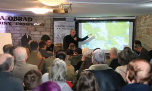 Prezentacja o Hubalu i jego szlaku bojowym. Mężczyzna wskazuje na mapę, a publiczność słucha.