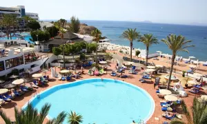 Relaks na basenie w hotelu Sandos, z widokiem na morze i palmami.